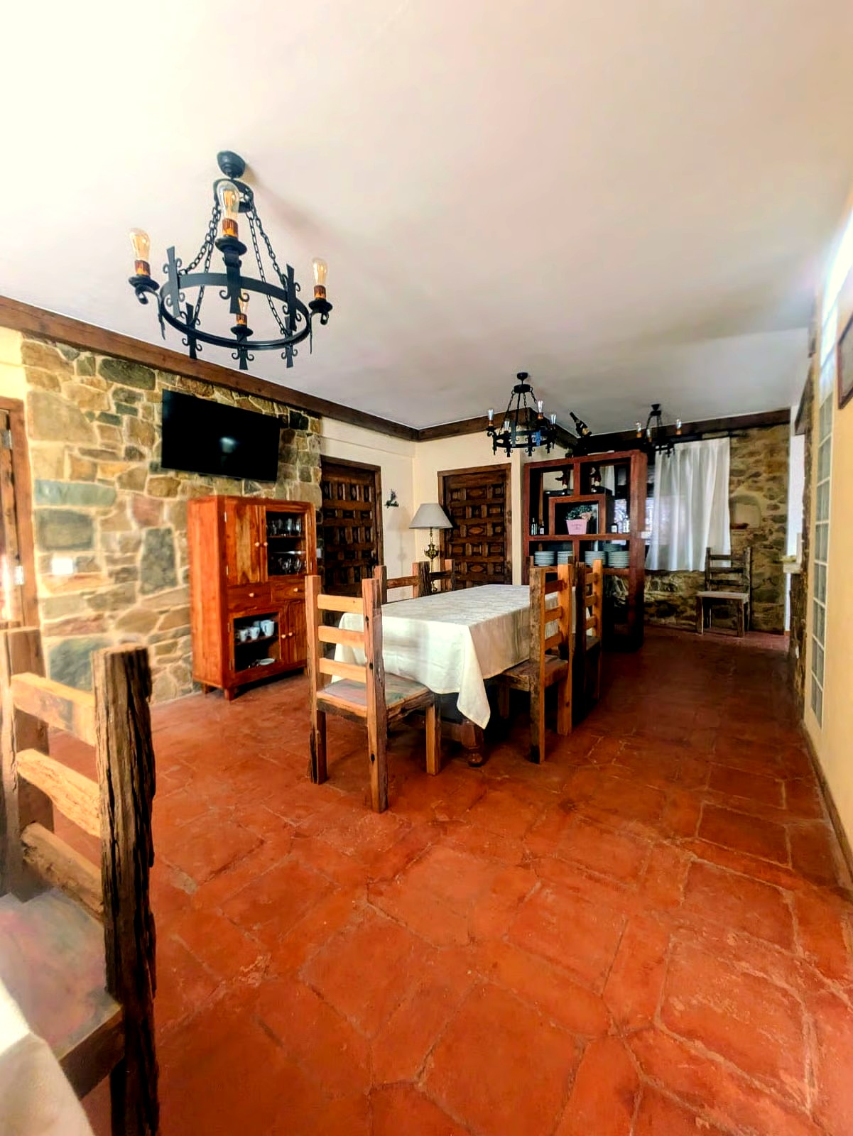 Salón con chimenea, vigas de madera y paredes de piedra